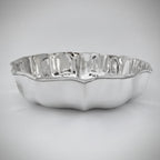 Silver bowl with wavy edge on a light gray background
