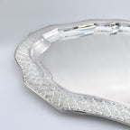 Silver tray with decorative edge on a light gray background