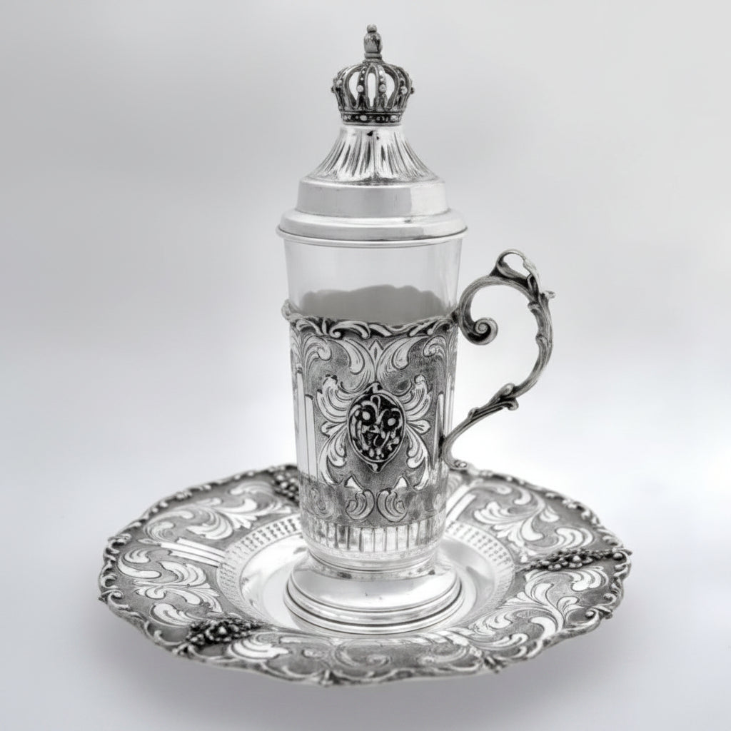 Silver teacup with lid and decorative elements on a white background