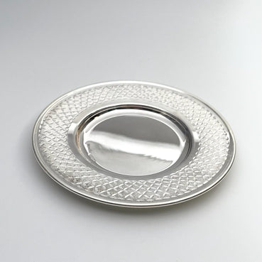 Silver textured plate on a light gray background