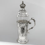 Silver teacup with intricate designs on a gray background