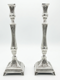 Pair of silver 925 candlesticks with intricate designs on a white background