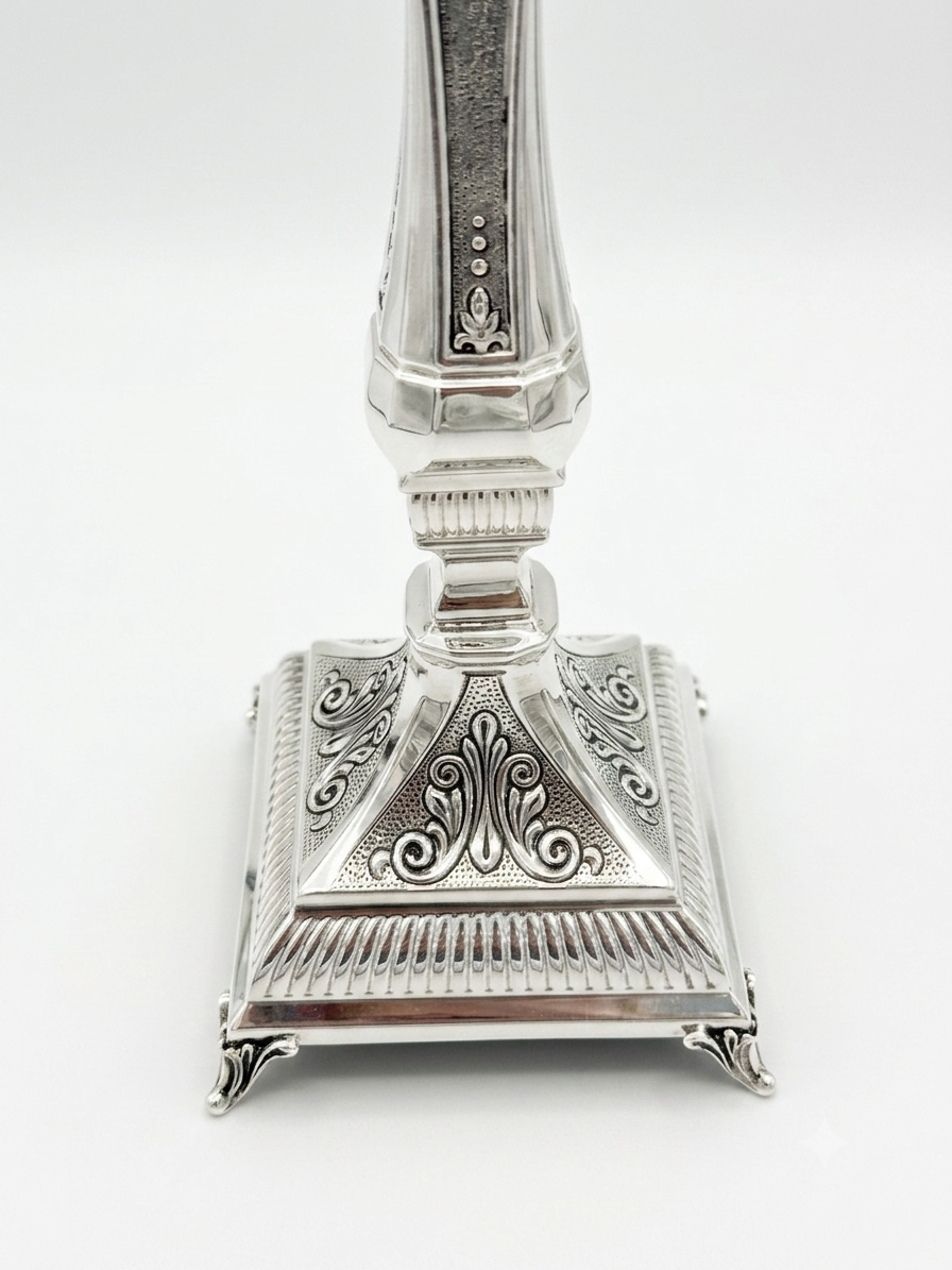 Pair of silver 925 candlesticks with intricate designs on a white background