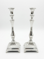 Pair of silver 925 candlesticks with intricate designs on a white background