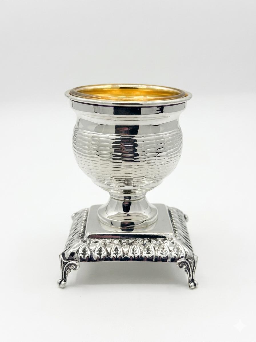 Silver and gold salt shaker cup on a white background