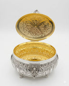 Decorative silver etrog box with intricate engravings on a white background