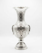 Silver vase with intricate designs on a white background