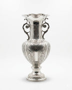 Silver vase with intricate designs on a white background