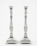 Two silver candlesticks on a white background