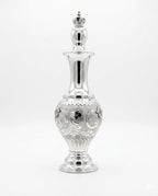 Silver decorative bottle with intricate designs on a white background