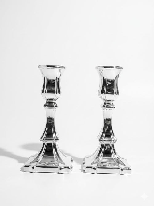 Two silver candle holders on a white background