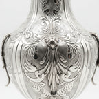 Silver vase with intricate designs on a white background