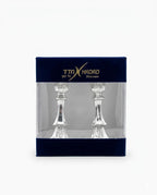 Two silver candlesticks in packaging with TTX Hadad branding on a white background