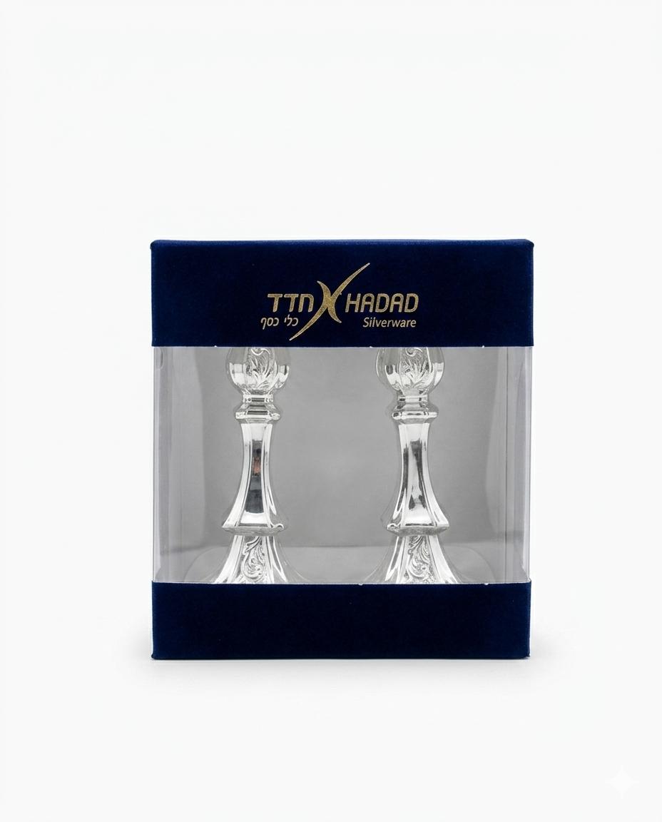 Two silver candlesticks in packaging with TTX Hadad branding on a white background