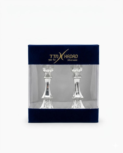 Two silver candlesticks in packaging with TTX Hadad branding on a white background