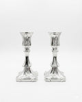Pair of silver candlesticks on a white background