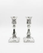 Pair of silver candlesticks on a white background