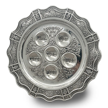 Decorative silver Seder plate with embossed design on a white background