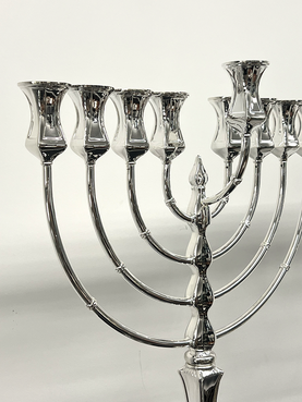 Silver Menorah with eight candles on a light gray background